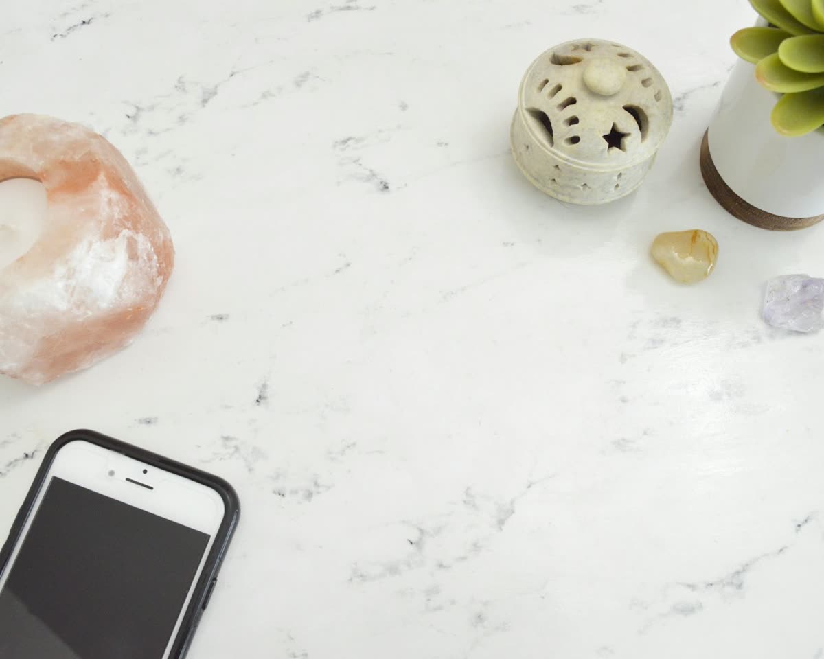 Hands holding a phone with the screen open, in a warm setting